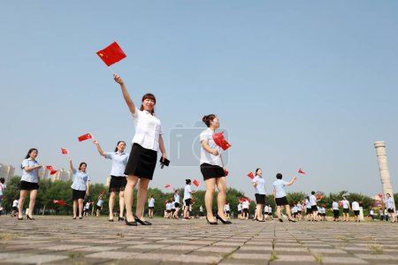 Photo for Luannan County, China - July 12, 2019: Ladies walking with Chinese flag in the park,  Luannan County, Hebei Province, China - Royalty Free Image