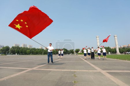 Foto de Condado de Luannan, China - 12 de julio de 2019: La gente del Parque Beihe ondeó la bandera china para dar la bienvenida al Día Nacional, Condado de Luannan, provincia de Hebei, China - Imagen libre de derechos