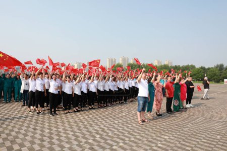 Foto de Condado de Luannan, China - 12 de julio de 2019: La gente ondeó banderas en la plaza, Condado de Luannan, provincia de Hebei, China - Imagen libre de derechos