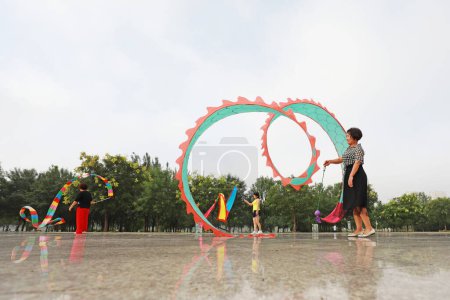 Foto de Condado de Luannan, China - 30 de julio de 2019: La gente agita cintas para ejercitarse en parques, Condado de Luannan, provincia de Hebei, China. - Imagen libre de derechos