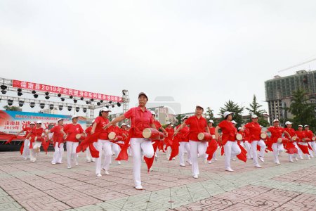 Foto de CONDADO DE LUANNAN, provincia de Hebei, China - 8 de agosto de 2019: Rendimiento de tambor de cintura fitness para ancianos en la plaza del parque. - Imagen libre de derechos