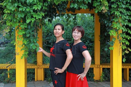 Téléchargez les photos : COMTÉ DE LUANNAN, province du Hebei, Chine - 8 août 2019 : Deux dames jouent sous le lierre dans le parc. - en image libre de droit