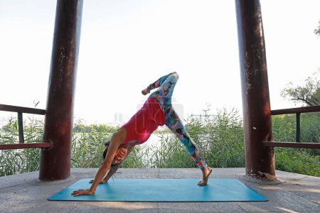 Foto de Condado de Luannan, China - 1 de septiembre de 2019: Las señoras practican yoga en parques, Condado de Luannan, provincia de Hebei, China - Imagen libre de derechos