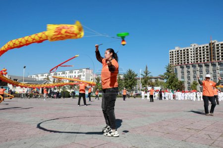 Photo for Luannan County, China - Oct. 8, 2019: Traditional Chinese Diabolo Fitness Exercise in Square, Luannan County, Hebei Province, China - Royalty Free Image