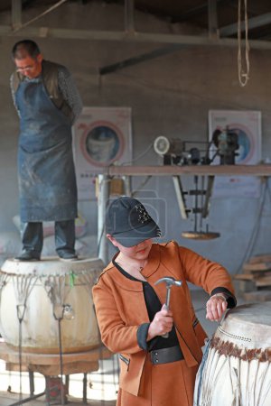 Téléchargez les photos : COMTÉ DE LUANNAN - 22 octobre 2019 : Le fabricant de tambours fabrique minutieusement du tambour en peau de vache, COMTÉ DE LUANNAN, province du Hebei, Chine - en image libre de droit