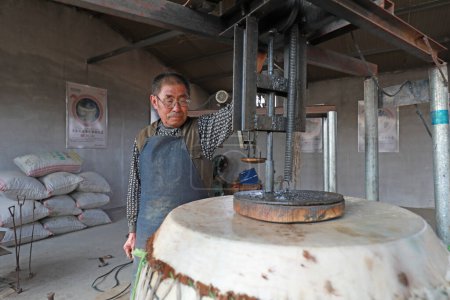Téléchargez les photos : COMTÉ DE LUANNAN - 22 octobre 2019 : Le fabricant de tambours fabrique minutieusement du tambour en peau de vache, COMTÉ DE LUANNAN, province du Hebei, Chine - en image libre de droit