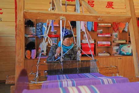Foto de Ciudad de Qian 'an - 25 de octubre de 2019: Una mujer teje tela por máquina, una artesanía tradicional china, Ciudad de Qian' an, provincia de Hebei, China - Imagen libre de derechos