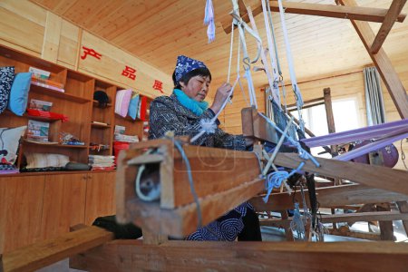 Photo for Qian'an city - October 25, 2019: A woman is weaving cloth by machine, a traditional Chinese folk craft, Qian'an City, Hebei Province, China - Royalty Free Image