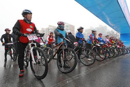 Foto de LUANNAN COUNTY, provincia de Hebei, China - 23 de noviembre de 2019: Los ciclistas están listos para la carrera, en un sitio de competición de ciclismo de carretera. - Imagen libre de derechos
