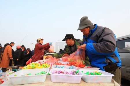 Foto de LUANNAN COUNTY, Provincia de Hebei, China - 17 de enero de 2020: Las personas que compran dulces están en el mercado rural. - Imagen libre de derechos