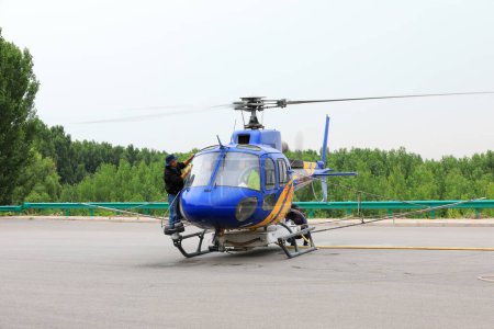 Téléchargez les photos : Comté de Luannan, Chine - 16 juin 2019 : Les travailleurs essuient les pare-brise des hélicoptères agricoles, comté de Luannan, province du Hebei, Chine - en image libre de droit