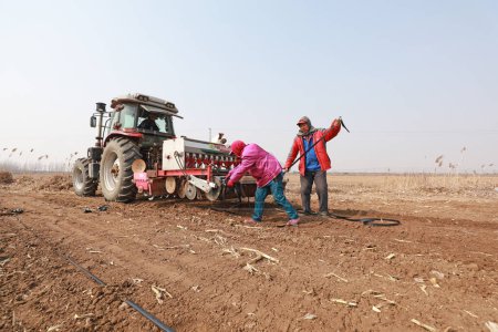 Foto de CONDADO DE LUANNAN, China - 6 de marzo de 2020: los agricultores utilizan plantadores para cultivar papas en granjas, condado de LUANNAN, provincia de Hebei, China - Imagen libre de derechos
