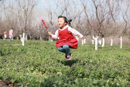 Téléchargez les photos : COMTÉ DE LUANNAN, Province du Hebei, Chine - 22 mars 2020 : Une petite fille joue dans la pelouse. - en image libre de droit