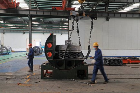 Foto de LUANNAN COUNTY, provincia de Hebei, China - 26 de marzo de 2020: Los trabajadores están ocupados en la línea de producción de tiras en una empresa de hierro y acero. - Imagen libre de derechos