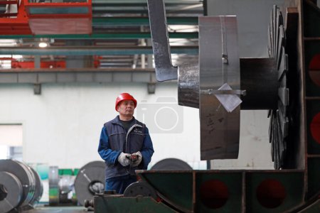 Photo for LUANNAN COUNTY, Hebei Province, China - March 26, 2020: Workers are busy on the strip production line in an iron and steel company. - Royalty Free Image