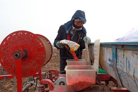 Foto de LUANNAN COUNTY, provincia de Hebei, China - 31 de marzo de 2020: Los agricultores están agregando agua, fertilizantes y semillas a la maquinaria para prepararse para la siembra. - Imagen libre de derechos