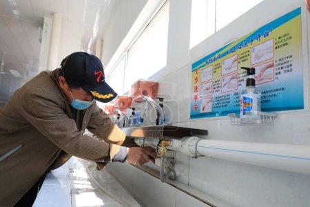 Téléchargez les photos : COMTÉ DE LUANNAN, province du Hebei, Chine - 13 avril 2020 : Le personnel a essuyé les meubles avec du désinfectant pour nettoyer l'environnement, la prévention de la nouvelle pneumonie par le coronavirus. - en image libre de droit