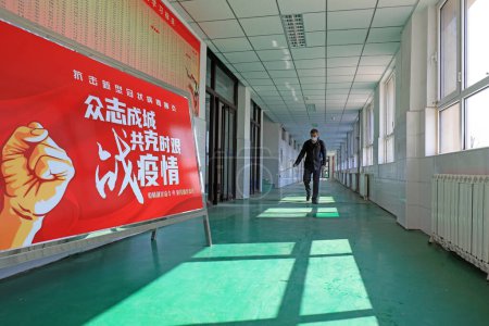 Photo for LUANNAN COUNTY, Hebei Province, China - April 13, 2020: Workers use sprayers to spray disinfectant in a school, prevention of novel coronavirus pneumonia. - Royalty Free Image