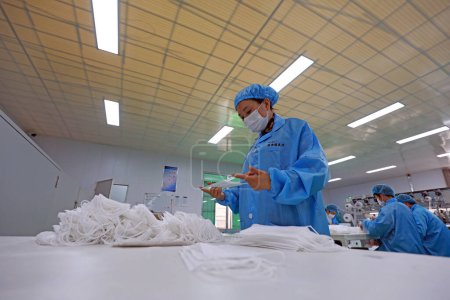Photo for LUANNAN COUNTY, Hebei Province, China - April 15, 2020: Workers are busy on the production line in a Medical mask factory. - Royalty Free Image