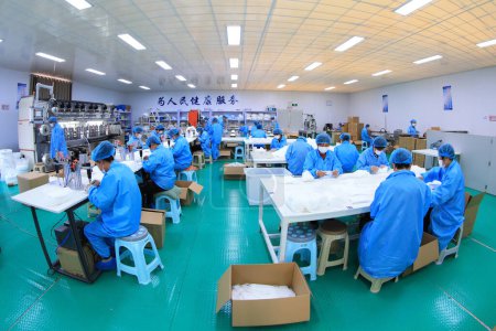 Photo for LUANNAN COUNTY, Hebei Province, China - April 15, 2020: Workers are busy on the production line in a Medical mask factory. - Royalty Free Image