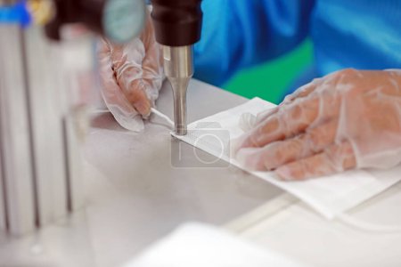Photo for Workers are busy on the production line in a Medical mask factory. - Royalty Free Image