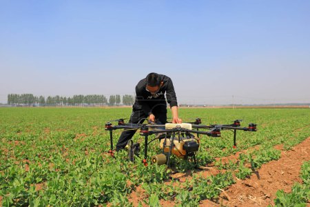 Photo for LUANNAN COUNTY, Hebei Province, China - April 27, 2020: A skilled worker is debugging the agricultural UAV, ready to spray pesticides. - Royalty Free Image