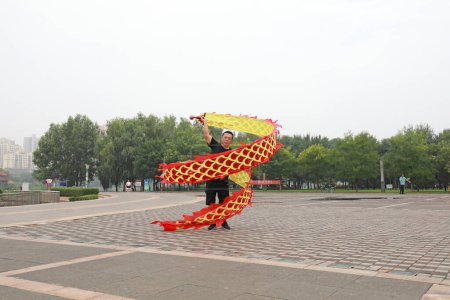 Foto de CONDADO DE LUANNAN, provincia de Hebei, China - 2 de agosto de 2020: La gente está sacudiendo la forma de la cinta en la plaza - Imagen libre de derechos