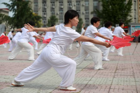 Photo for LUANNAN COUNTY, Hebei Province, China - August 8, 2020: People are practicing Tai Chi fans in the square - Royalty Free Image