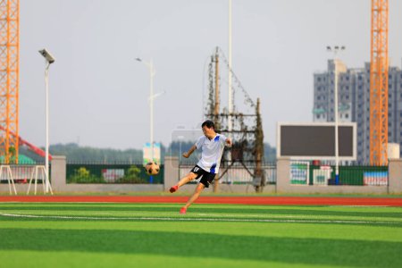 Foto de LUANNAN COUNTY, provincia de Hebei, China - 23 de agosto de 2020: Los jóvenes juegan al fútbol en el césped - Imagen libre de derechos