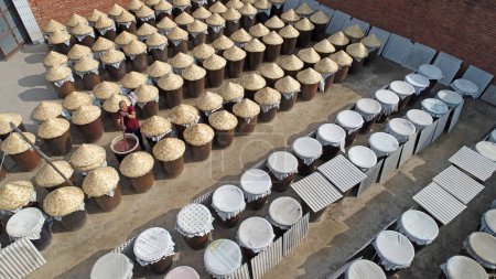 Téléchargez les photos : Conteneurs d'huile de crevette marinée empilés dans la cour, Chine du Nord - en image libre de droit