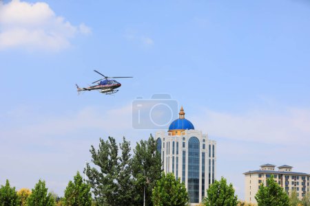 Photo for LUANNAN COUNTY, Hebei Province, China - September 7, 2020: Agricultural helicopters for controlling Hyphantria cunea spray pesticides over the city - Royalty Free Image