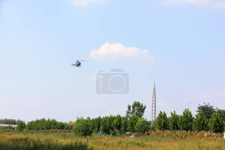 Photo for Agricultural helicopters for controlling Hyphantria cunea spray pesticides over the city - Royalty Free Image