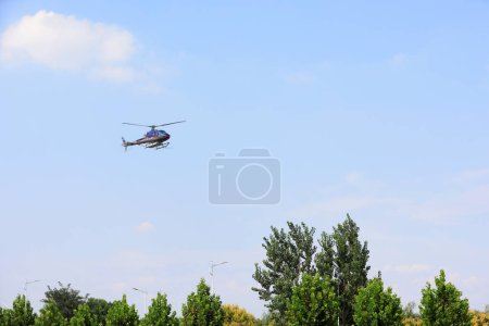 Foto de CONDADO DE LUANNAN, provincia de Hebei, China - 7 de septiembre de 2020: Helicópteros agrícolas para el control de los pesticidas en aerosol Hyphantria cunea sobre la ciudad - Imagen libre de derechos