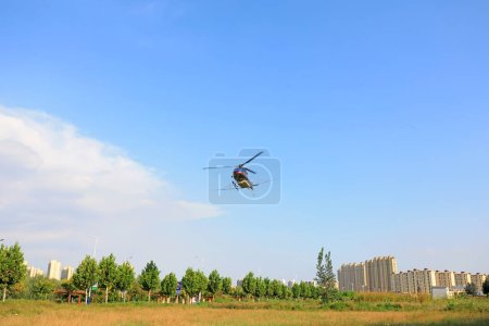 Téléchargez les photos : Hélicoptères agricoles pour contrôler les pesticides Hyphantria cunea pulvérisation sur la ville - en image libre de droit
