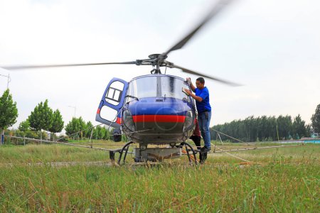Foto de CONDADO DE LUANNAN, provincia de Hebei, China - 7 de septiembre de 2020: Trabajadores repostan y medican helicóptero agrícola - Imagen libre de derechos