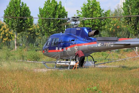 Téléchargez les photos : COMTÉ DE LUANNAN, province du Hebei, Chine - 7 septembre 2020 : Des travailleurs ravitaillent en carburant et médicamentent un hélicoptère agricole - en image libre de droit