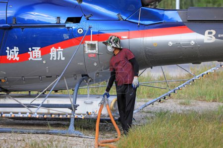 Téléchargez les photos : COMTÉ DE LUANNAN, province du Hebei, Chine - 7 septembre 2020 : Des travailleurs ravitaillent en carburant et médicamentent un hélicoptère agricole - en image libre de droit