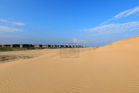 Foto de Casas de madera y dunas de arena sobre un fondo de cielo azul - Imagen libre de derechos