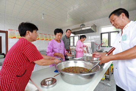 Téléchargez les photos : COMTÉ DE LUANNAN, Province du Hebei, Chine - 14 septembre : Les personnes âgées mangent dans une petite cantine dans une zone rurale, Chine du Nord - en image libre de droit