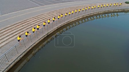 Téléchargez les photos : Les femmes pratiquent le yoga au bord de la rivière dans le parc, photos aériennes, Chine du Nord - en image libre de droit