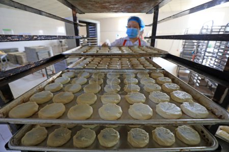 Foto de LUANNAN COUNTY, provincia de Hebei, China - 27 de septiembre de 2020: Los trabajadores de la línea de producción de pasteles lunares trabajan duro en la planta de procesamiento de alimentos - Imagen libre de derechos