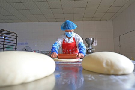 Photo for LUANNAN COUNTY, Hebei Province, China - September 27, 2020: Workers on the moon cake production line work hard in the food processing plant - Royalty Free Image