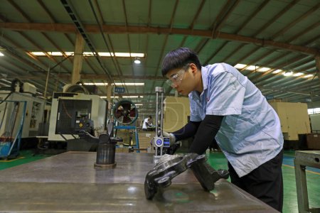Foto de LUANNAN COUNTY, provincia de Hebei, China - 29 de septiembre de 2020: Jóvenes trabajadores en la inspección de la calidad del producto en la plataforma de trabajo - Imagen libre de derechos