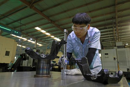 Foto de LUANNAN COUNTY, provincia de Hebei, China - 29 de septiembre de 2020: Jóvenes trabajadores en la inspección de la calidad del producto en la plataforma de trabajo - Imagen libre de derechos