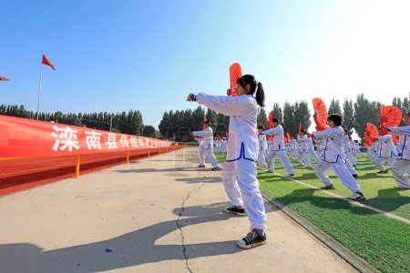Téléchargez les photos : COMTÉ DE LUANNAN, province du Hebei, Chine - 30 septembre 2020 : Des élèves du collège pratiquent Taiji Fan sur l'aire de jeux - en image libre de droit