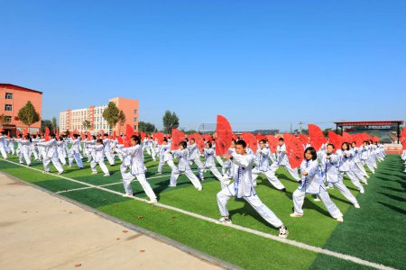 Foto de LUANNAN COUNTY, provincia de Hebei, China - 30 de septiembre de 2020: Estudiantes de secundaria practican Taiji Fan en el patio de recreo - Imagen libre de derechos