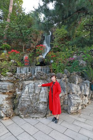 Téléchargez les photos : Pékin, Chine - 3 octobre 2020 : Les touristes jouent devant la cascade artificielle du temple Hongluo à Pékin - en image libre de droit