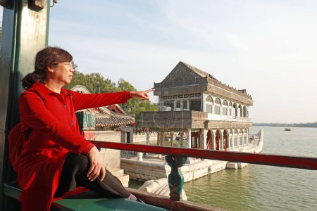 Photo for Beijing, China - October 6, 2020: A lady in red is visiting the summer palace in Beijing - Royalty Free Image
