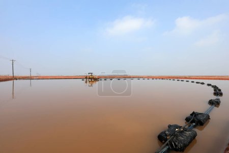 Photo for The raw salt production equipment operates in a crystallizer in a salt farm, North China - Royalty Free Image