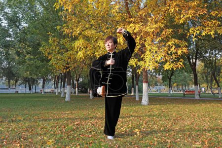 Foto de LUANNAN COUNTY, Provincia de Hebei, China - 18 de octubre de 2020: La gente practica Taijiquan en el bosque - Imagen libre de derechos